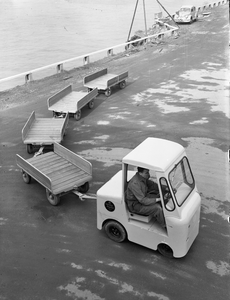 821696 Afbeelding van een Lansing Bagnall elektrowagen met enkele aanhangwagens voor intern transport op het terrein ...